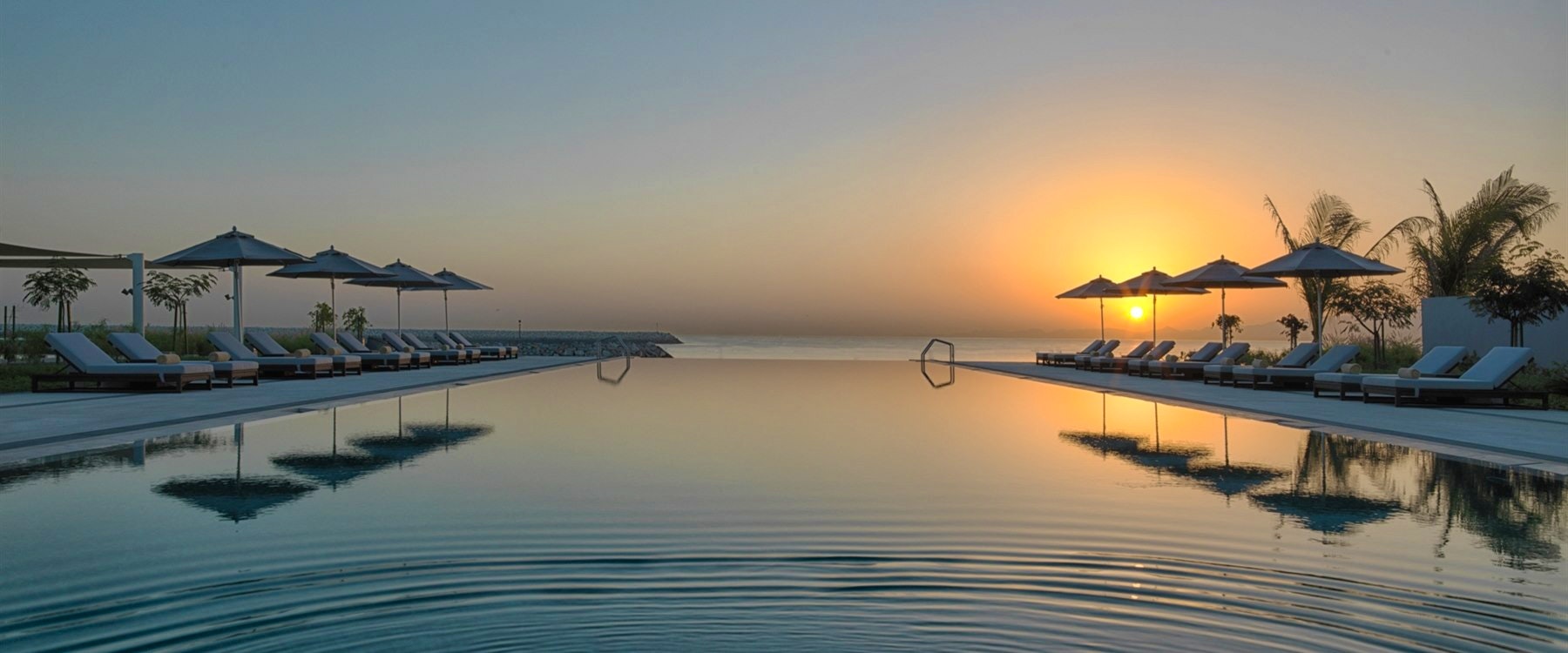 Infinity pool at sunrise at Kempinski Hotel Muscat, Oman