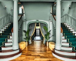 entrance hallway and grand staircase at the vanderbilt auberge resorts collection