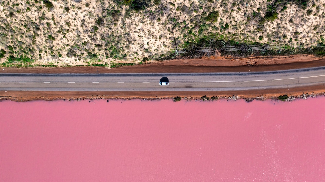 aerial image bird eye view of pink lake and a car in port gregory western australia