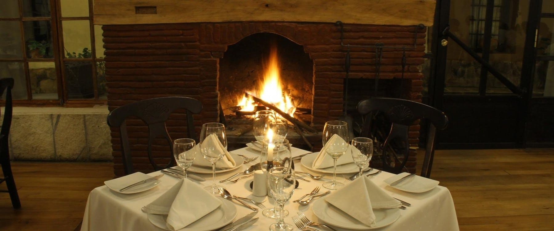 Restaurant table in front of fireplace, Sonesta Posada del Inca Yucay